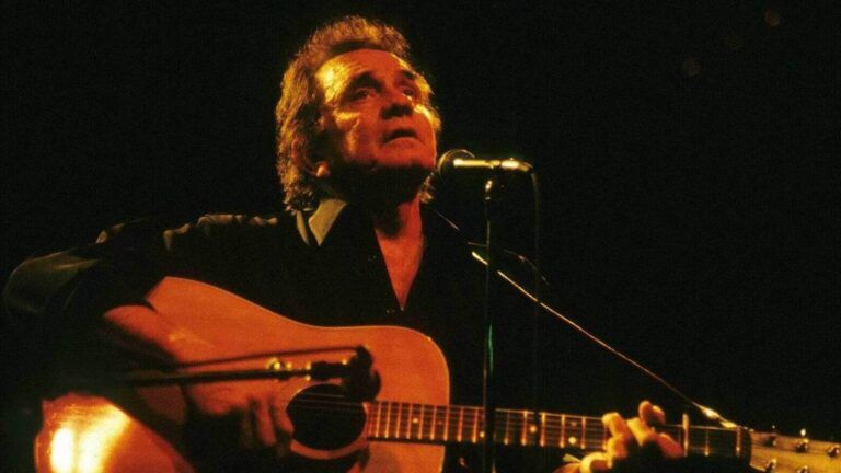 Johnny Cash playing onstage about his story of faith