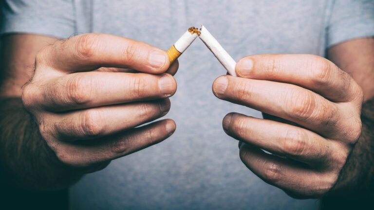 Man breaking a cigarette in half; Getty Images