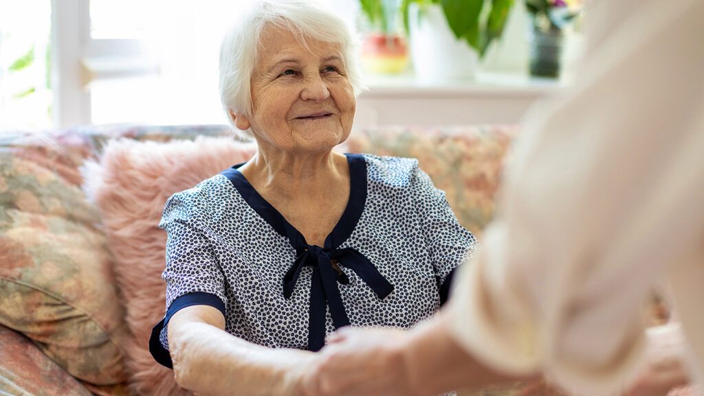 An Alzheimer's patient smiles at her caregiver