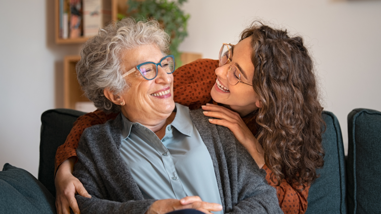 Daughter laughing with an aging loved one; Getty Images