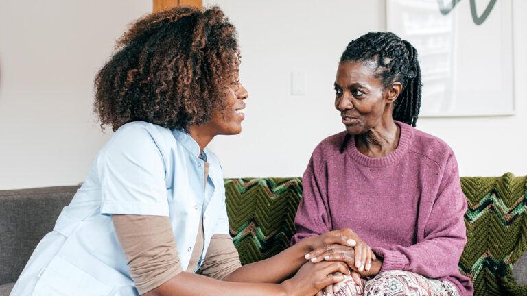 Caregiver listening to senior woman
