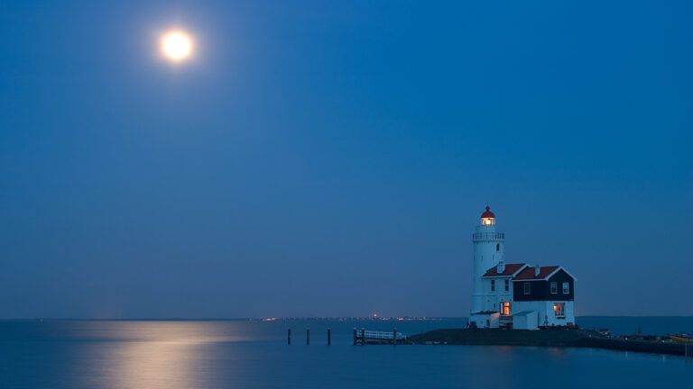 Moon shining over a lighthouse