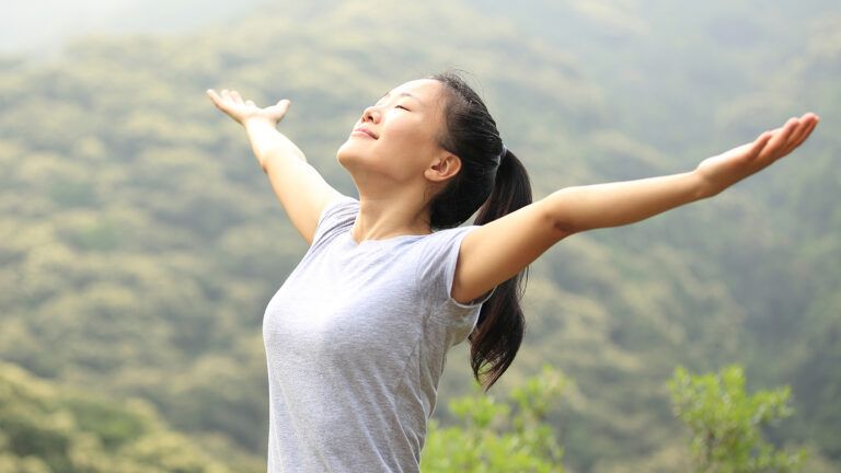 A woman raises her arms in joy