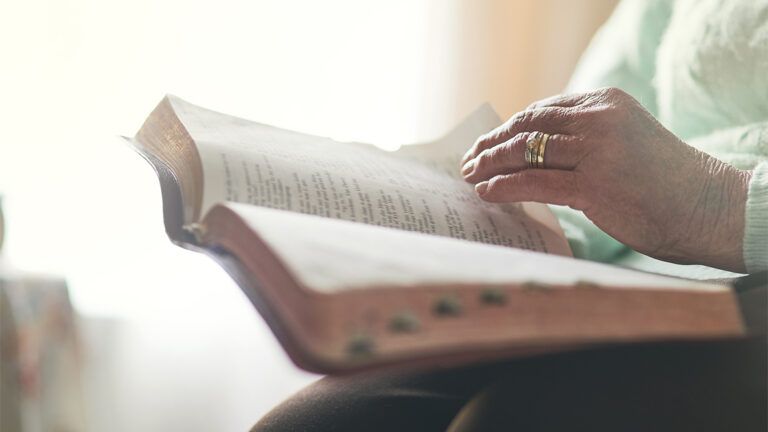 A woman's hands hold an open Bible
