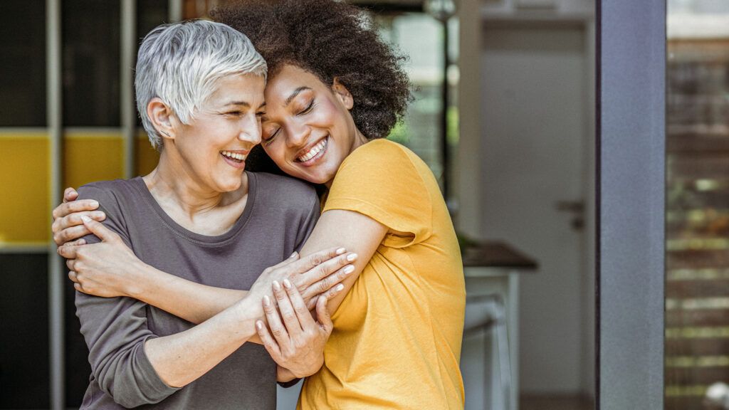 Two women hugging to learn the different between gratitude and thankfulness