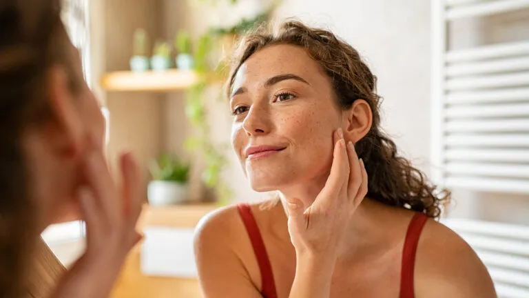 Woman looking at herself in the mirror reflecting on ash wednesday