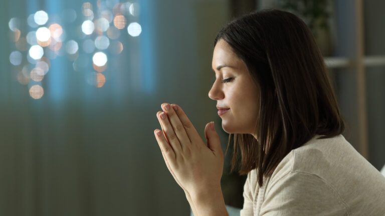 Woman saying an evening prayer of gratitude before bed