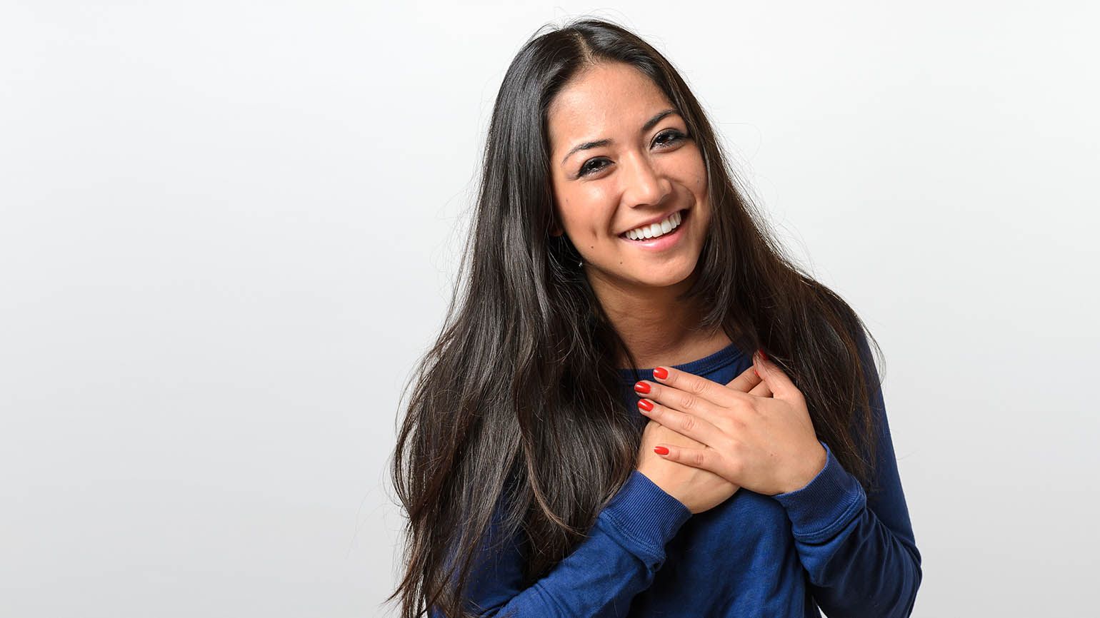 Woman with her hands on her heart to show her gratitude vs thankfulness