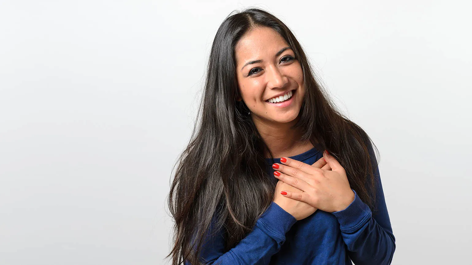 Woman with her hands on her heart to show her gratitude vs thankfulness