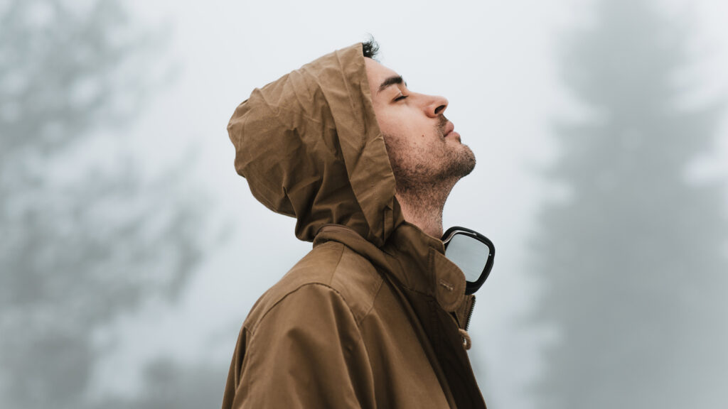 A man outside looking up and praying for the advent theme of peace