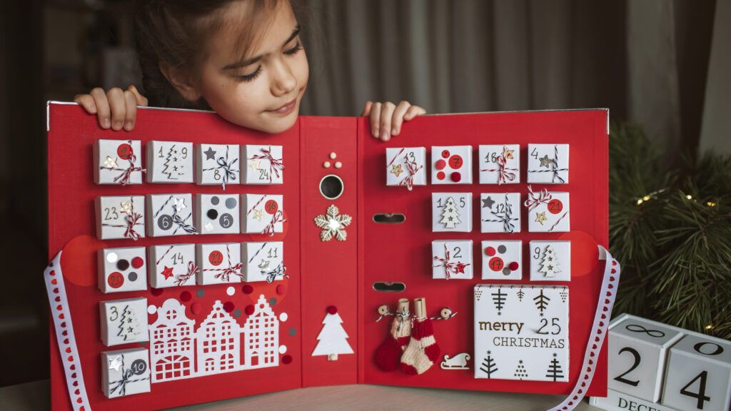 Young girl holding advent calendar showing what is advent