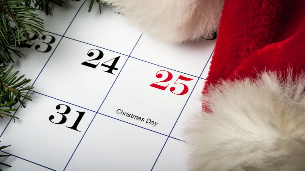 A calendar with holly and a santa hat showing Christmas Day on December 25