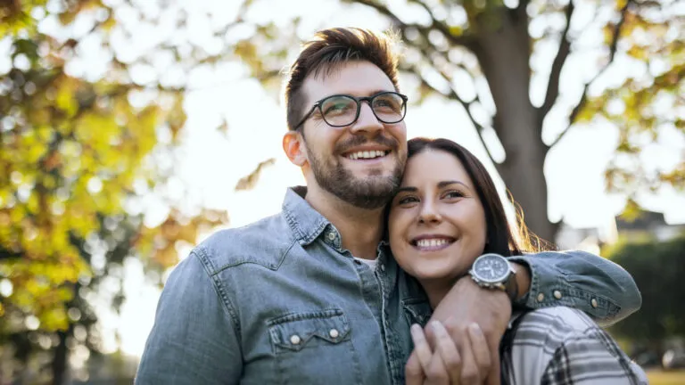 A couple make a marriage habit of hugging outside in autumn