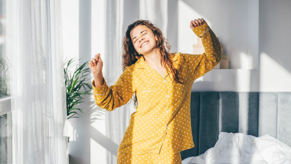 A woman in yellow pajamas makes dancing a part of her morning positive habit