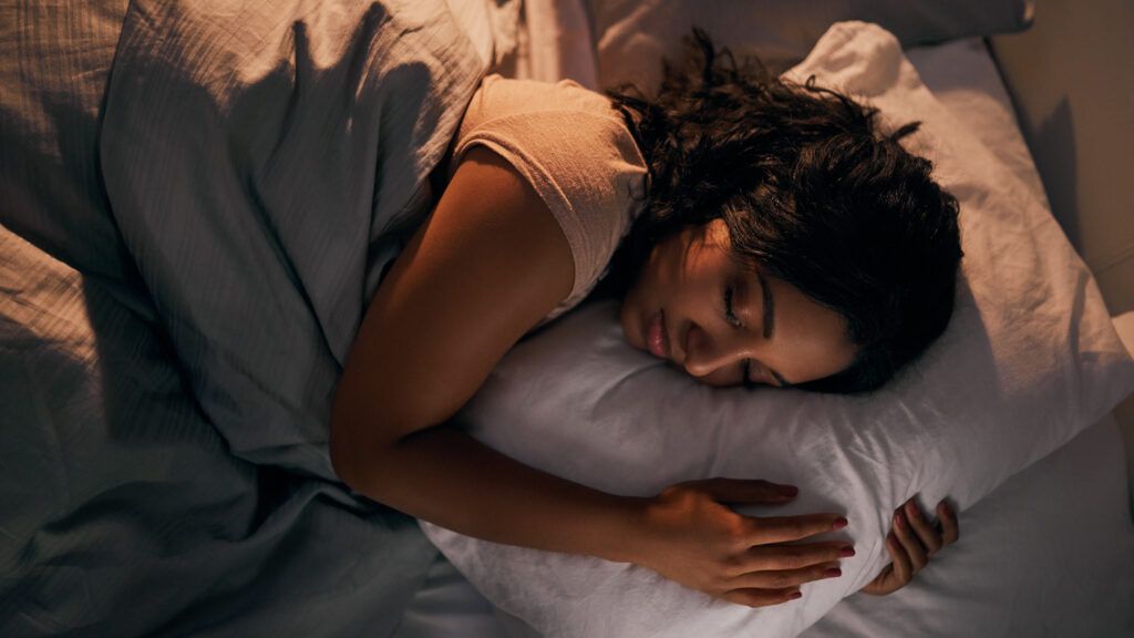 A woman sleeping in her bed after doing a bedtime positive habit