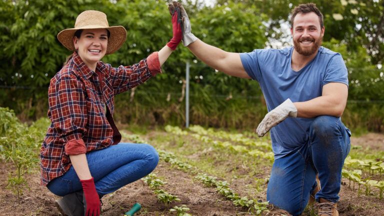 Couple high fiving while gardening together to increase joy in marriage