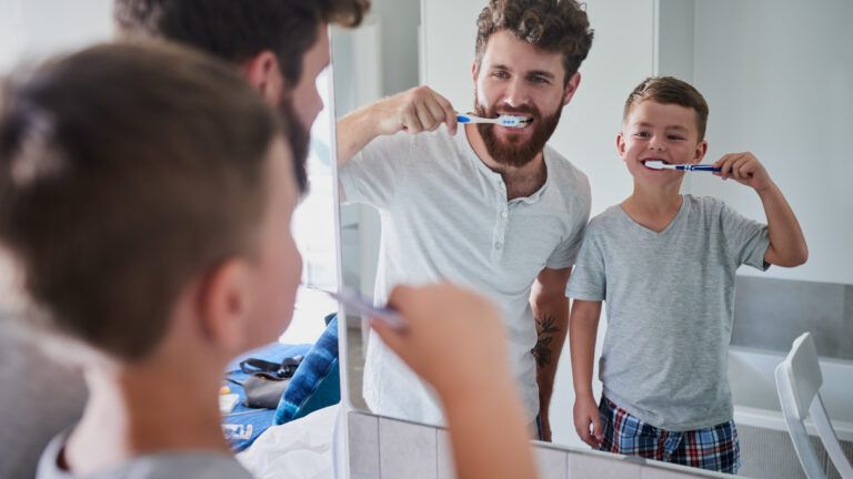 Father and son brushing teeth as a bedtime habit