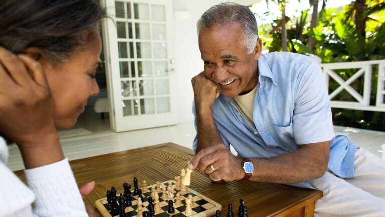 Senior couple playing chess together to increase joy in their marriage