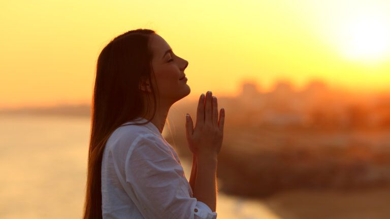 Woman at sunset praying as a micro habit for spiritual growth