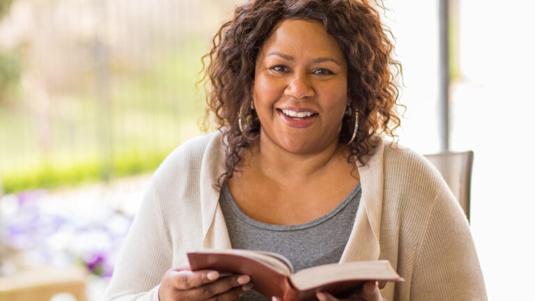 Woman holding a Bible with verses about habits