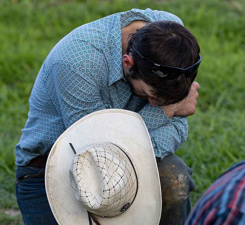 A bull rider bows his head in prayer; photo by Wade Payne