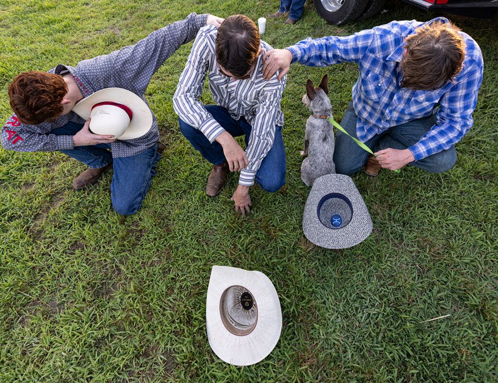 Young cowboys pray; photo by Wade Payne