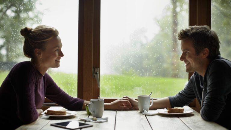 Couple holding hands at the breakfast table discussing faith in marriage