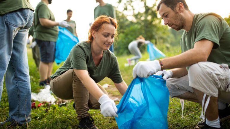 Couple volunteering to collect trash together to build the faith in their marriage