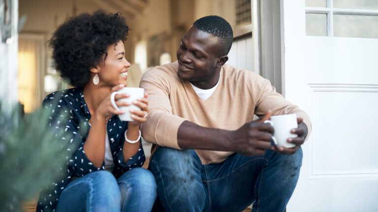 Couple with coffee on the porch talking together about faith in marriage