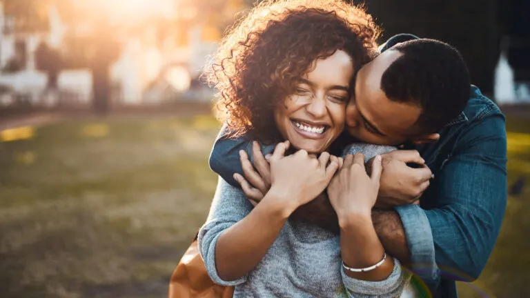 Happy couple hugging each other outside after reading Bible verses about love