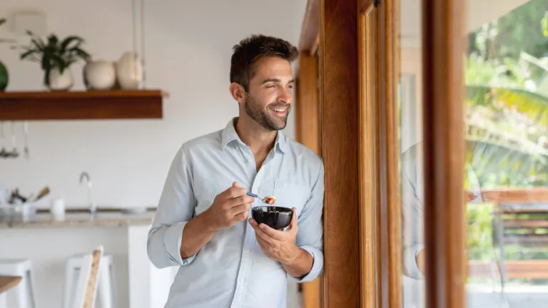 Man eats breakfast by his window for his new years habit