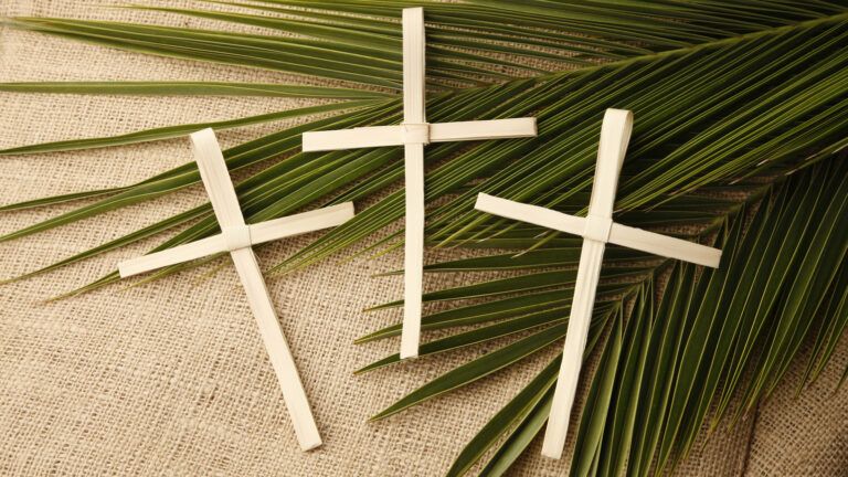 Palm crosses lying on palm leaves as lent gifts
