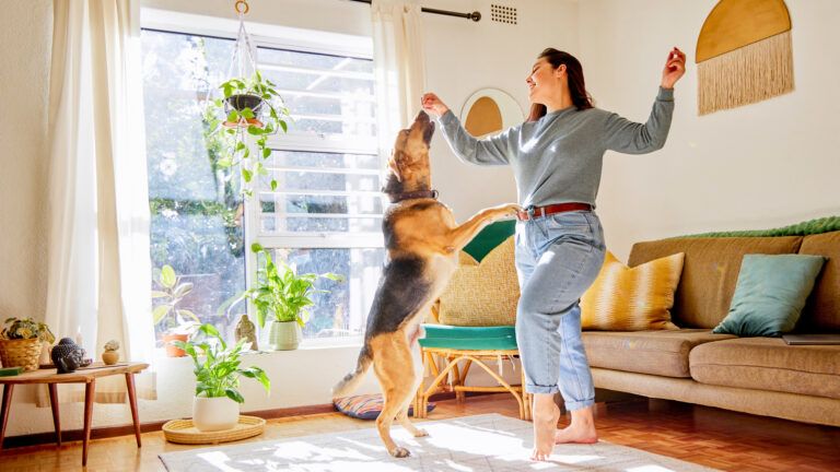 Woman dancing with her dog to happiness quotes