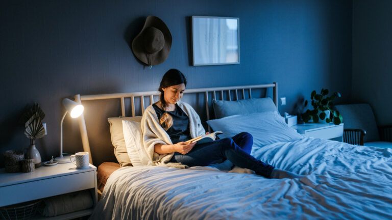 Woman reading a book in bed as her new years habit