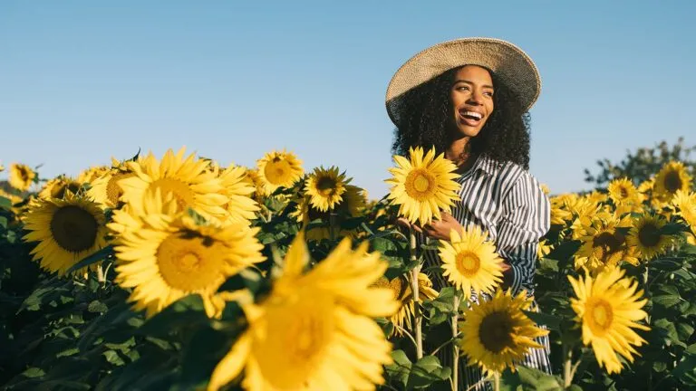 Woman standing in a yellow flower field smiling about the lent colors