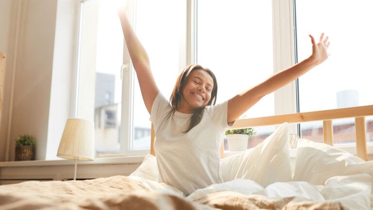 Woman waking from her bed in the morning ready to do her new habits