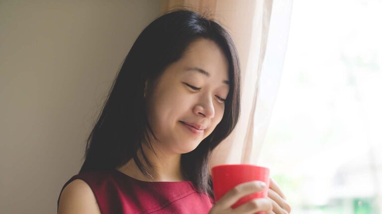 Woman with a red mug meditates about the lent colors