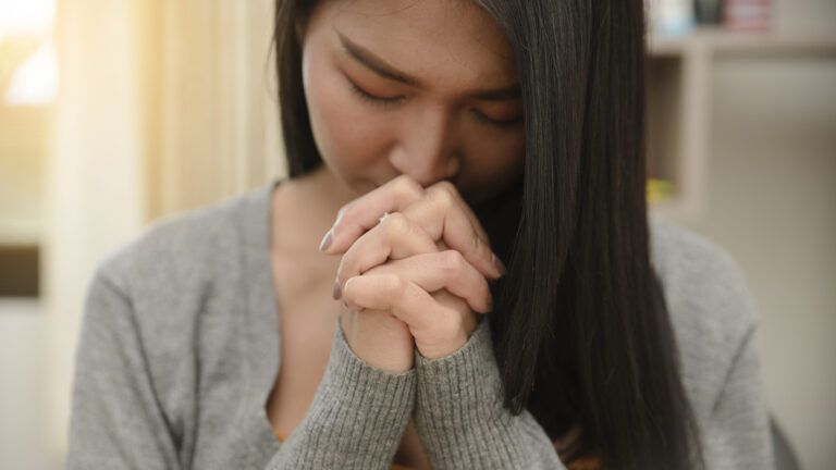 Young woman trying to pray effectively with her hands together