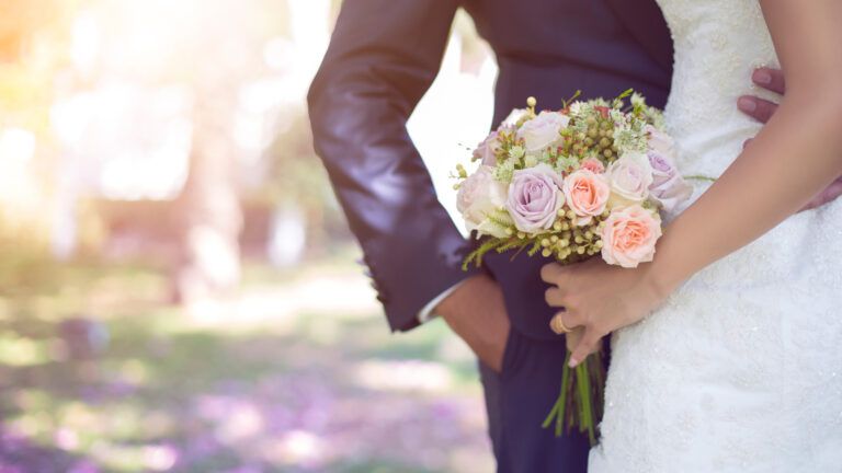 Newlywed couple with focus on bouquet.