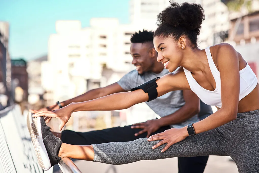 A young married couple stretches prior to exercising