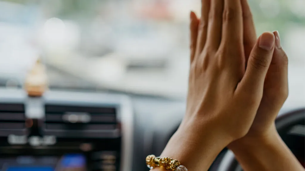 Praying hands in a car.