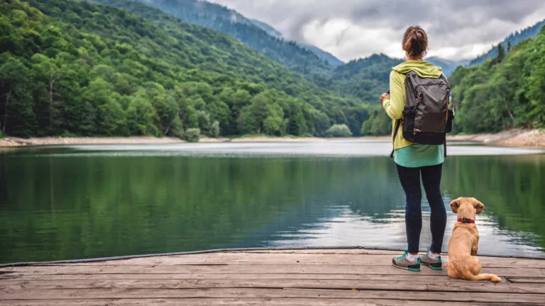 woman hiking in the woods for lent in the bible with her puppy