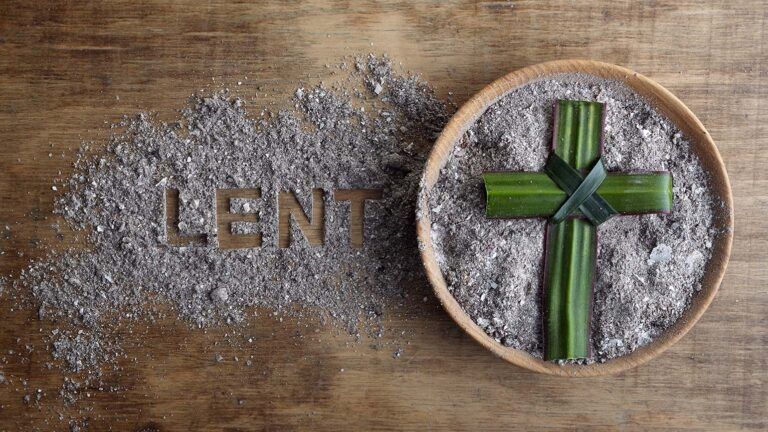 Ashes and a palm cross with what is lent written in the ashes