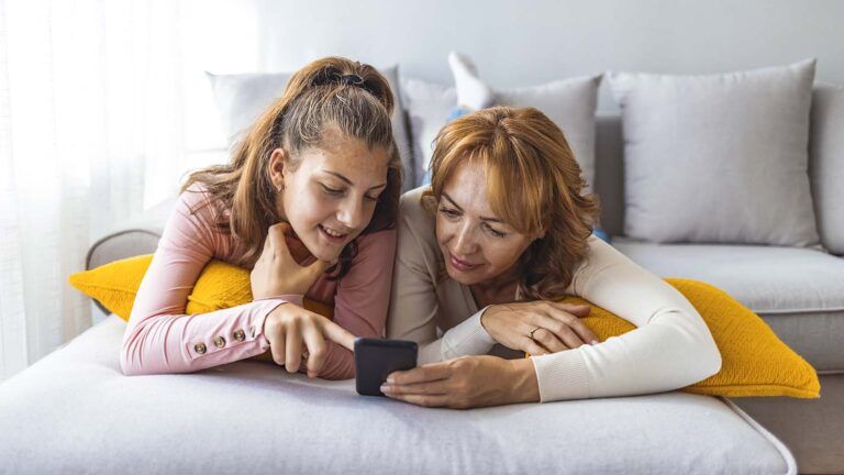 Mother and her teen daughter looking at their lent goals on a smartphone