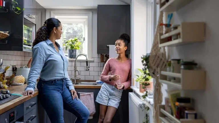 Mother and teen daughter in the kitchen together discussing their lent goals