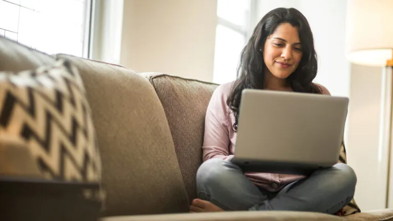 Woman paying bills online, an eco-friendly method.