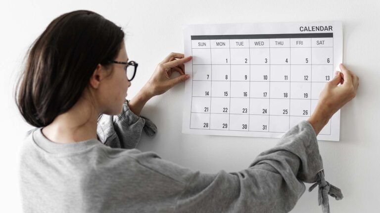 Woman putting a calendar on the wall to mark her lent plan