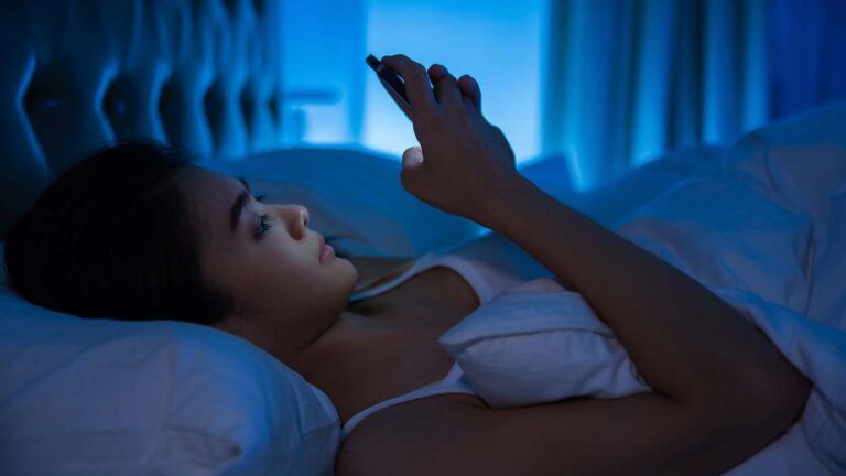 Women using her phone in bed at night for her Lenten journey