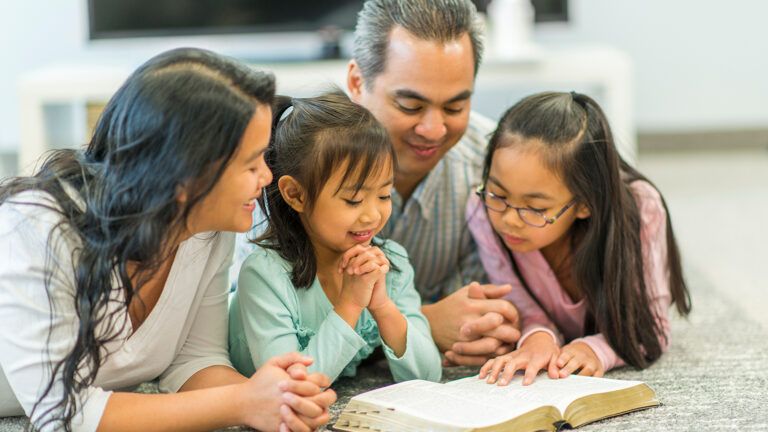 A family reads the Bible together; Getty Images