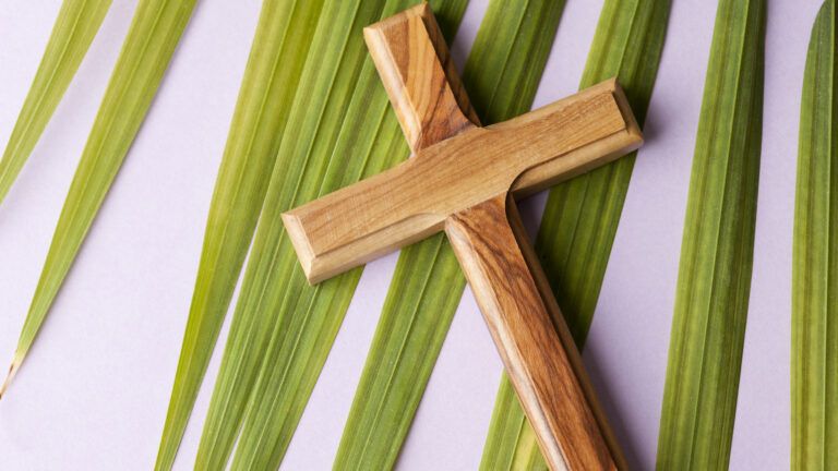 Wooden cross with fresh palm. 8 Prayers for Holy Week